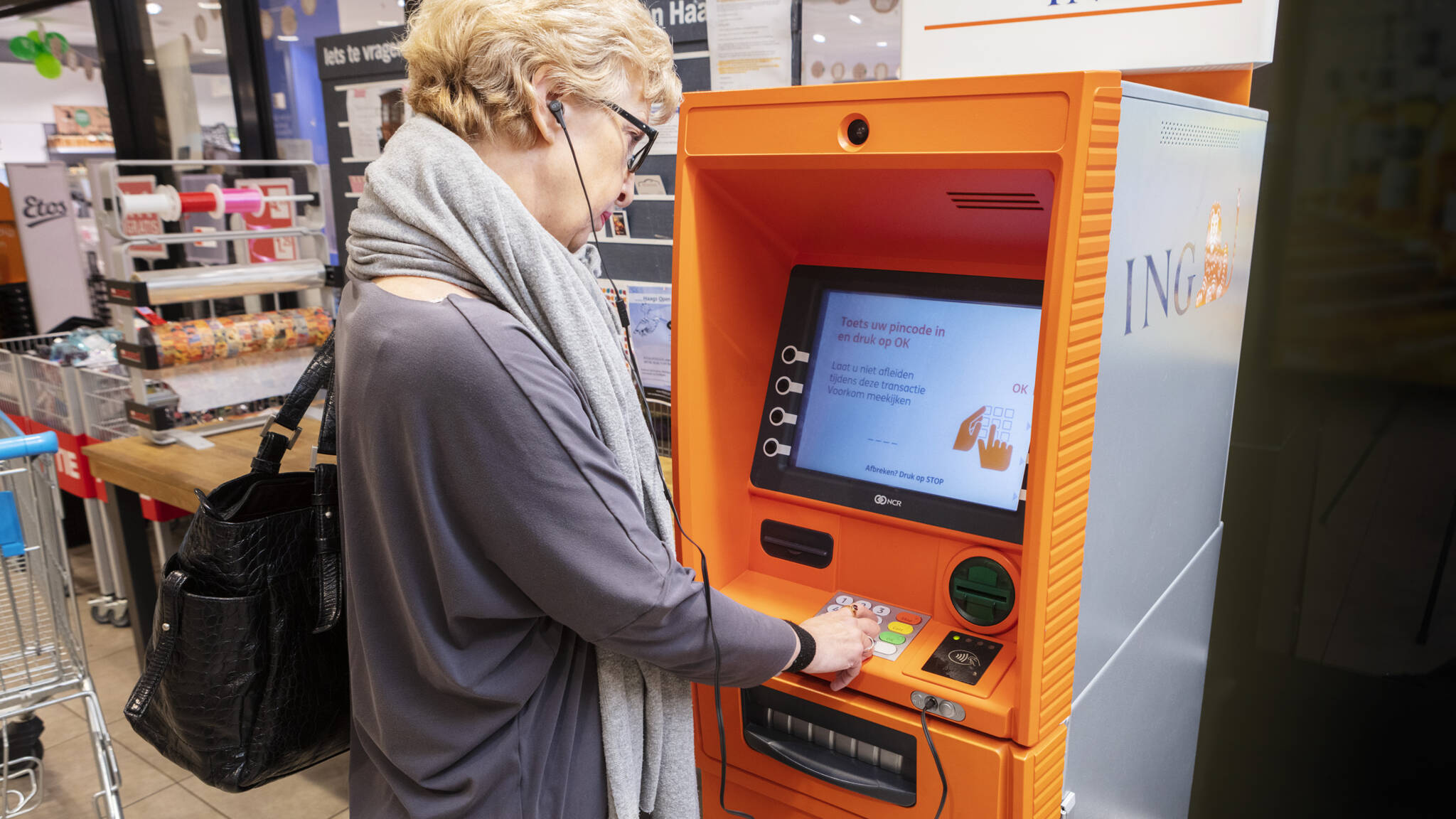 geldautomaat met vrouw die geld opneemt